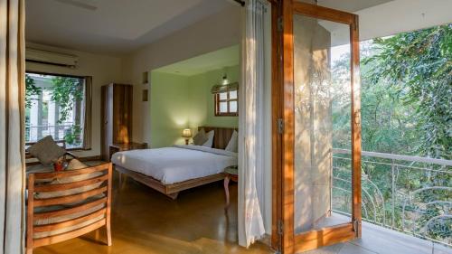 a bedroom with a bed and a large window at The Chitvan Resort in Ajmer