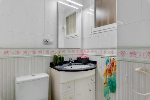 een badkamer met een wastafel, een spiegel en een toilet bij Apartment Manzanera 5 - PlusHolidays in Calpe