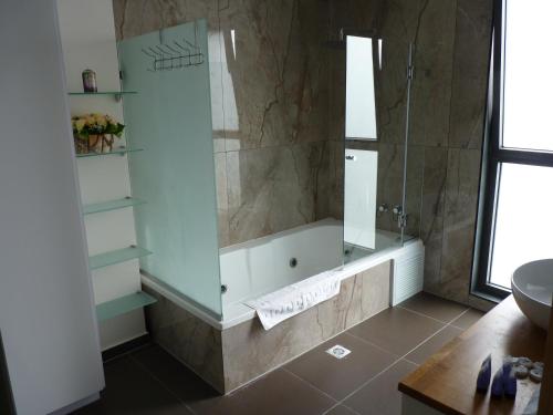 a bathroom with a shower and a tub and a sink at JTower Royal Suites - The Penthouse - Alefimmoed in Jerusalem