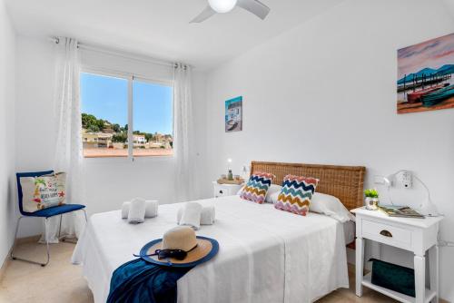 een witte slaapkamer met 2 bedden en een raam bij Apartment Manzanera 5 - PlusHolidays in Calpe