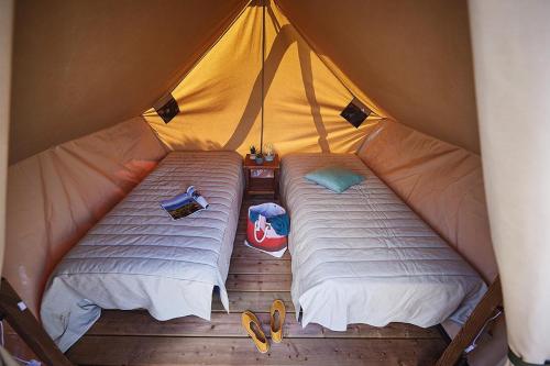een paar bedden in een tent bij Camping Les Pommiers in Sotteville-sur-Mer