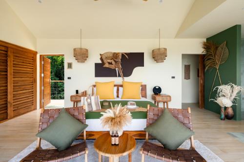 a bedroom with a bed and a table and chairs at Wild Cottages Elephant Sanctuary Resort in Amphoe Koh Samui