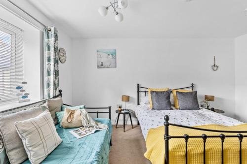 a bedroom with two beds and a couch at 17 At The Beach, Torcross in Torcross
