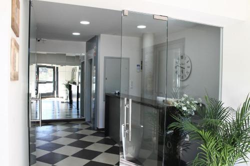 艾莫臘的住宿－蘭德旅館，走廊上设有玻璃门和墙上的时钟