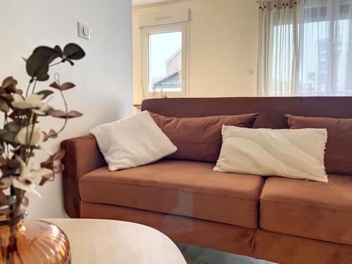 a brown couch with pillows in a living room at Le Julia - Neuf - Gare et garage in Compiègne