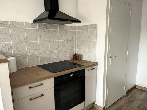 a kitchen with a sink and a stove top oven at Le Julia - Neuf - Gare et garage in Compiègne
