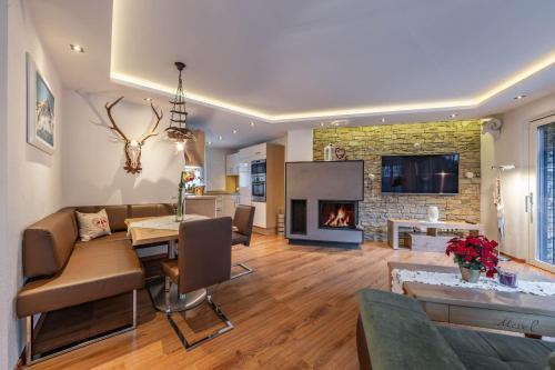 a living room with a dining table and a fireplace at Chalet Perauer in Mayrhofen