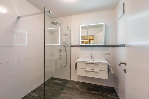 a white bathroom with a sink and a shower at Appartement Perauer in Mayrhofen