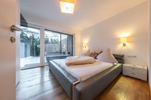 a bedroom with a bed and a large window at Chalet Perauer in Mayrhofen