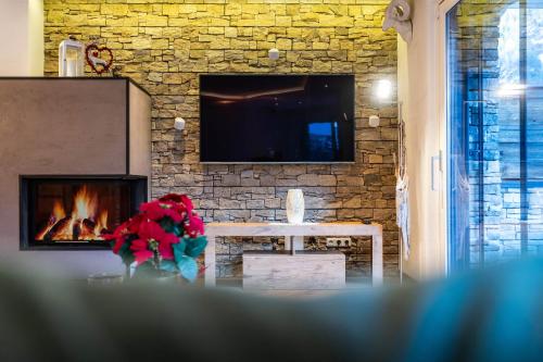 a living room with a fireplace and a table with flowers at Chalet Perauer in Mayrhofen