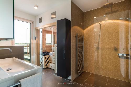 y baño con lavabo y ducha. en Luxusferienhaus Kap Baltic Sea, en Olpenitz