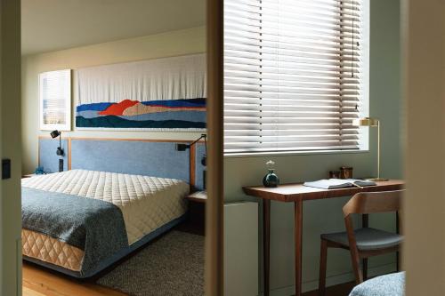um quarto com uma cama, uma secretária e uma janela em Gilreu Beach Duplex Apartments in Foz by LuxiStay em Porto