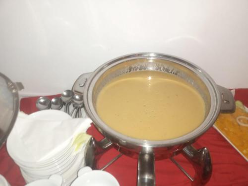a pot filled with a yellow liquid on a stove at Mountain View Hotel in La Digue