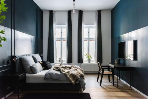 a bedroom with blue walls and a bed and a desk at Exklusive Luxus-Unterkunft in Berlin Mitte: 2 Apartments, 130m², Designer-Möbel, Co2 neutrale Reinigung in Berlin