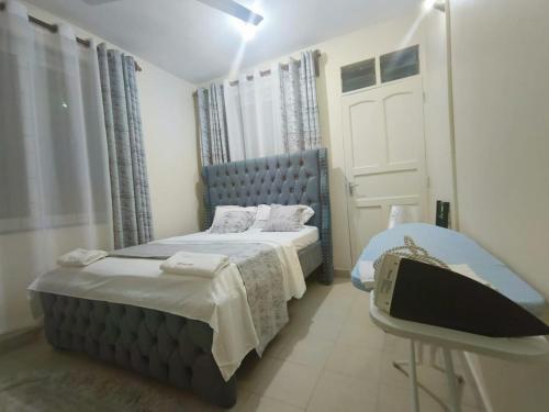 a bedroom with a blue bed and a window at Joly Apartments, Nyali Mombasa in Mombasa