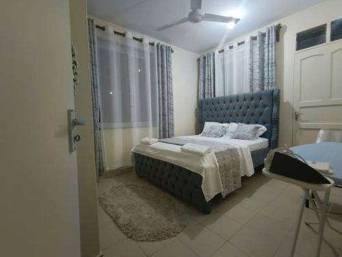 Un dormitorio con una cama azul y una ventana en Joly Apartments, Nyali Mombasa, en Mombasa