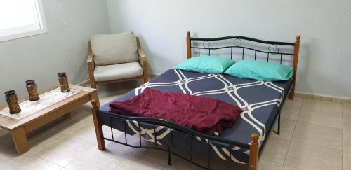 a bedroom with a bed with a chair and a table at HOUSE IN AL AIN in Al Ain