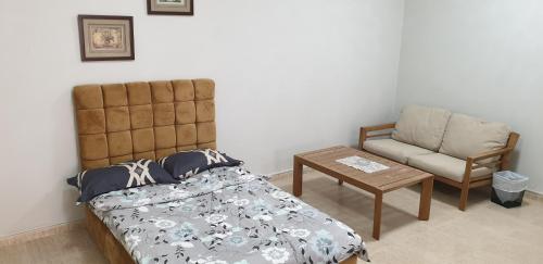 a bedroom with a bed and a chair at HOUSE IN AL AIN in Al Ain
