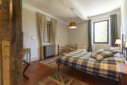 a bedroom with a bed and a desk and a window at Le Gavachon in Leboulin