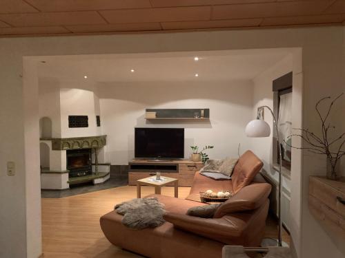 a living room with a couch and a flat screen tv at Böhms Ferienwohnungen in Friedrichsbrunn