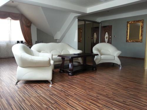 un soggiorno con sedie bianche e un tavolo di Apartment Kotva a Bratislava