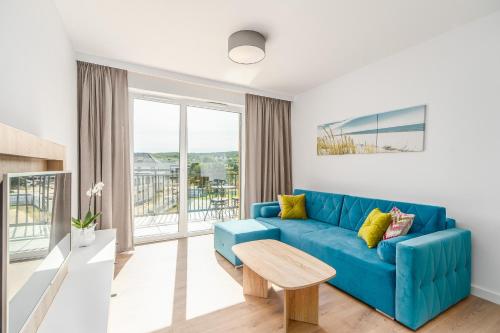 sala de estar con sofá azul y mesa en Perfect Holiday Apartments Bel Mare by Renters, en Międzyzdroje