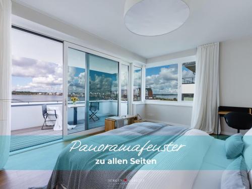 a bedroom with a large bed and a balcony at Harbour Lodge: Meerblick, Terrasse, Balkon, finnische Sauna, Kaminofen in Olpenitz