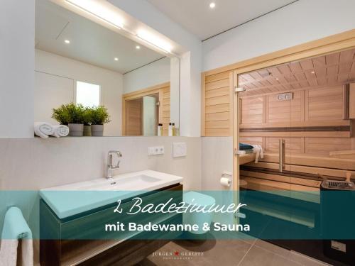 a bathroom with a sink and a mirror at Harbour Lodge: Meerblick, Terrasse, Balkon, finnische Sauna, Kaminofen in Olpenitz