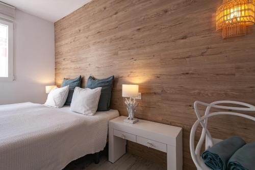 um quarto com uma cama branca e uma parede de madeira em Apartment BEACH & RELAX em Port de Pollensa