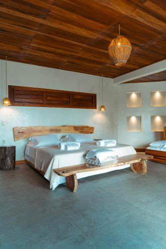 a bedroom with two beds and a wooden ceiling at Vila Caetanos in Amontada