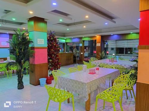 un restaurante con mesas y sillas amarillas en una habitación en Atlantic Resort, en Jaliapāra