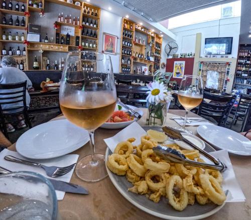 einen Tisch mit einem Teller mit Essen und Gläsern Wein in der Unterkunft Park Regis Concierge Apartments in Sydney