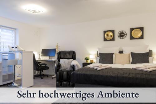 1 dormitorio con 1 cama y escritorio con ordenador en RelaxApartment 2 Massagesessel SmartTV Küche, en Biberach an der Riß