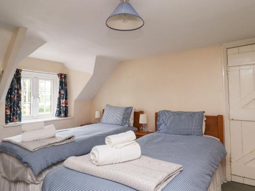 Cette chambre comprend 2 lits jumeaux dans un dortoir bleu. dans l'établissement Cherry Tree Cottage, à Embleton