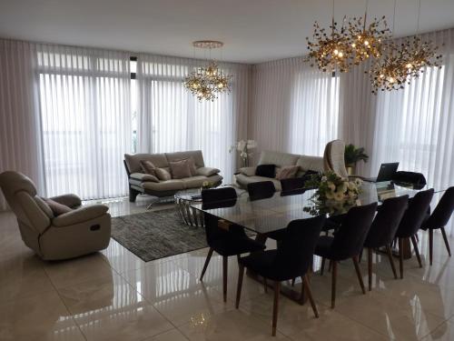 a living room with a glass table and chairs at JTower Royal Suites - The Penthouse - Alefimmoed in Jerusalem