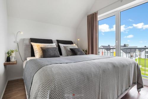 um quarto com uma cama e uma grande janela em Ferienwohnung Santiano Lounge em Olpenitz