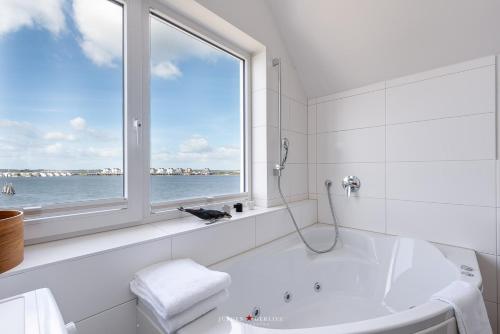 a bathroom with a bath tub and a window at Ferienwohnung Hafenkieker in Olpenitz
