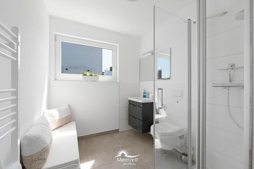 a white bathroom with a shower and a toilet at Harbour View Marina: Dachterrasse, Meerblick, Sauna, Bootsanleger in Olpenitz