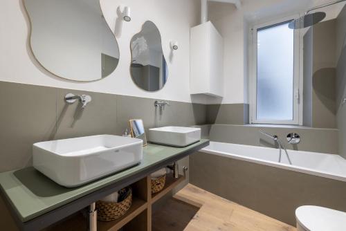 een badkamer met 2 wastafels, een bad en een spiegel bij Urban Chic 2 BR Vatican Escape in Rome