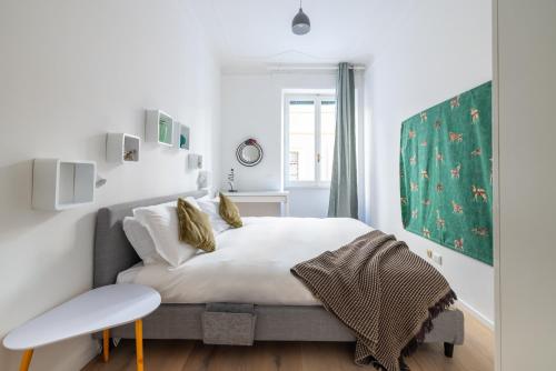 een witte slaapkamer met een bed en een raam bij Urban Chic 2 BR Vatican Escape in Rome