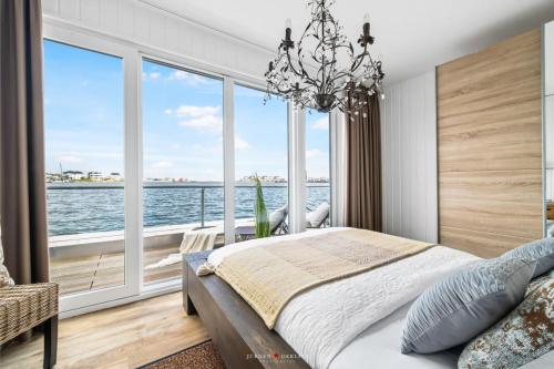 a bedroom with a bed and a large window at Wasserhaus Villa Sansibar in Olpenitz