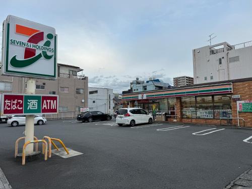 a parking lot with cars parked in front of a store at MR TOMO FUJI in Fuji