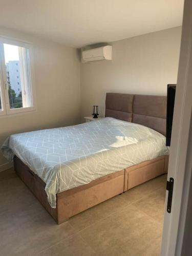 une chambre avec un lit dans une pièce avec une fenêtre dans l'établissement Appartement MARTINEZ 4 couchages, à Cannes