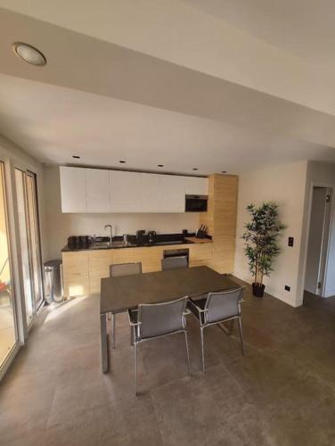 une cuisine avec une table et des chaises dans une pièce dans l'établissement Appartement MARTINEZ 4 couchages, à Cannes