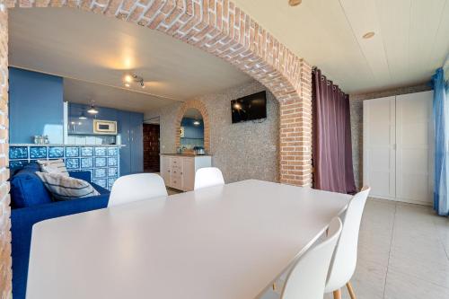 sala de estar con mesa blanca y sillas blancas en Hauzify I Apartament Plenamar, en Platja d'Aro