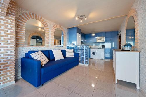 sala de estar con sofá azul en la cocina en Hauzify I Apartament Plenamar, en Platja d'Aro