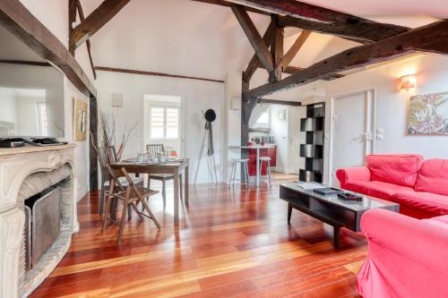 uma sala de estar com um sofá vermelho e uma lareira em Nid d'Artiste - 5min à pied du château em Versailles