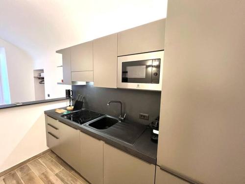 a kitchen with a sink and a microwave at Suite Arnaldo 10 - Sanremo in Sanremo