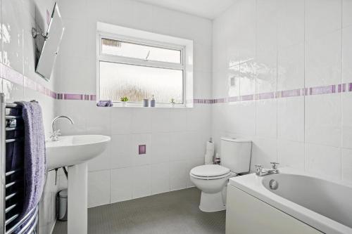 La salle de bains blanche est pourvue de toilettes et d'un lavabo. dans l'établissement The Stylish Warwick Abode - Balcony - Garden, à Leek Wootton
