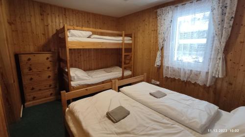 two bunk beds in a room with a window at Penzion U Rybníka in Mariánská